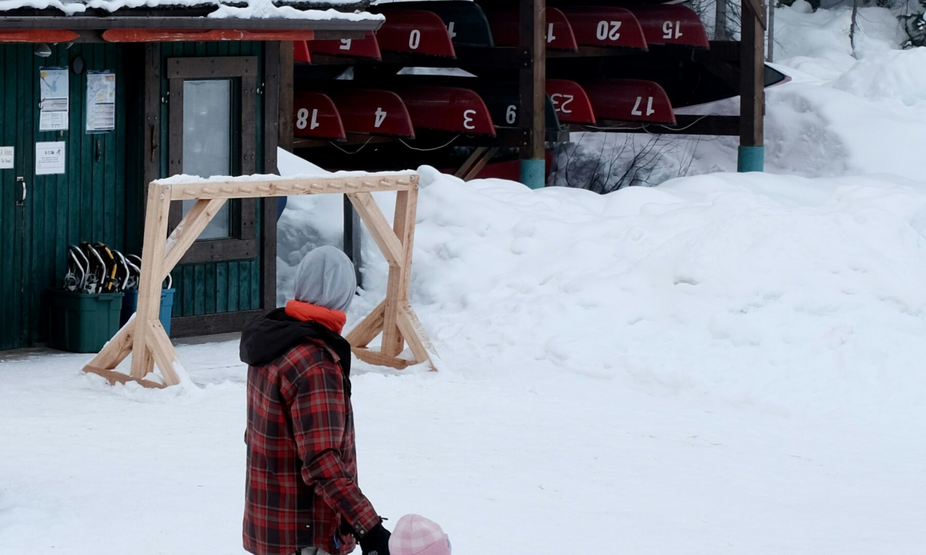 Ouder en kind wandelen samen door een besneeuwd winterlandschap
