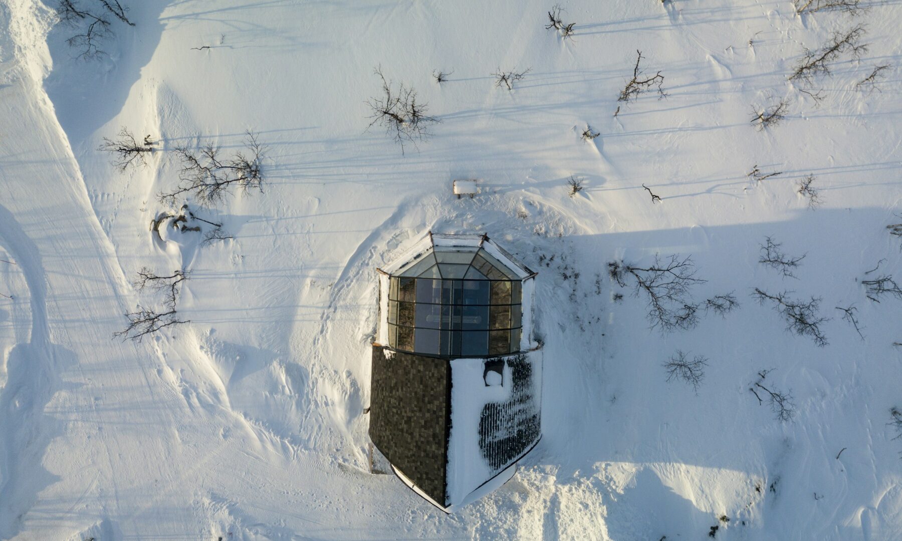 Glazen iglo van bovenaf in een besneeuwd landschap in Kilpisjärvi, Finland
