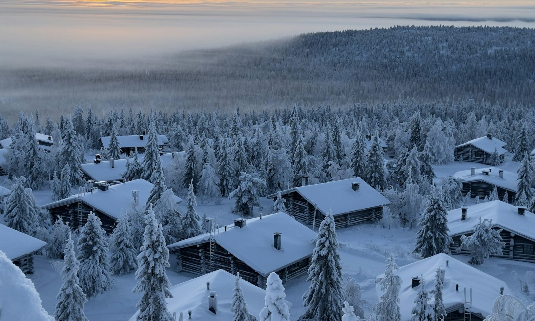 Besneeuwd dorp tussen winterse bossen in Fins Lapland